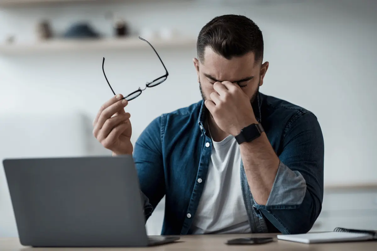 a man holding a hand to his face and suffering from dry eye